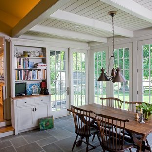 Cette photo montre une salle à manger chic avec un mur blanc et un sol en ardoise.