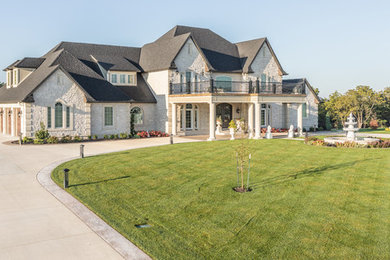 Large elegant white two-story stone house exterior photo in Other