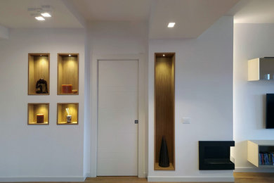 Foto di un grande ingresso moderno con pareti bianche, parquet chiaro, una porta singola, una porta bianca, pavimento marrone e soffitto ribassato