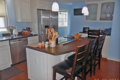 Inspiration for a mid-sized transitional l-shaped medium tone wood floor and brown floor eat-in kitchen remodel in Other with an undermount sink, raised-panel cabinets, white cabinets, quartz countertops, multicolored backsplash, stainless steel appliances, an island and multicolored countertops