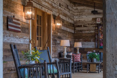 This is an example of a mid-sized rustic front porch design in Charlotte with a roof extension.