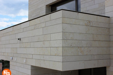 Foto de fachada beige con revestimiento de piedra