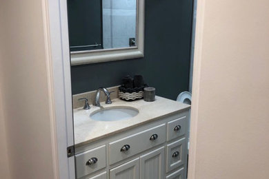 Example of a mid-sized classic alcove shower design in Los Angeles with recessed-panel cabinets, white cabinets, gray walls, an undermount sink, quartz countertops and beige countertops