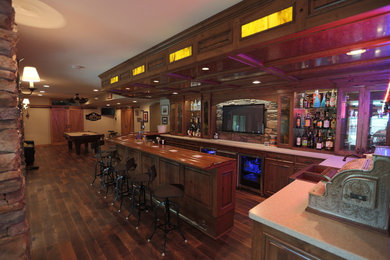 Foto di un grande bancone bar stile rurale con lavello da incasso, ante con bugna sagomata, ante in legno scuro, top in legno, paraspruzzi in ardesia e parquet scuro