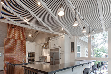 Eat-in kitchen - large transitional u-shaped light wood floor eat-in kitchen idea in New York with shaker cabinets, white cabinets, white backsplash, subway tile backsplash, stainless steel appliances, an undermount sink, soapstone countertops and a peninsula