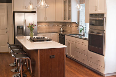 Transitional medium tone wood floor kitchen photo in Other with an undermount sink, white cabinets, gray backsplash, glass tile backsplash, stainless steel appliances, an island, shaker cabinets and quartzite countertops