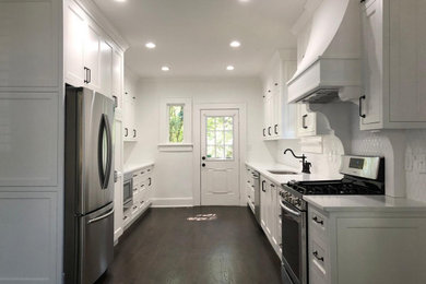 This is an example of a mid-sized galley eat-in kitchen in Atlanta with an undermount sink, shaker cabinets, white cabinets, quartzite benchtops, dark hardwood floors, brown floor and white benchtop.
