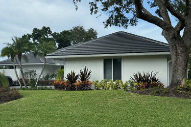 Mid-sized transitional white one-story stucco house exterior photo in Miami with a hip roof, a tile roof and a gray roof