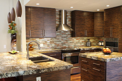 Inspiration for a mid-sized contemporary u-shaped medium tone wood floor eat-in kitchen remodel in Phoenix with a drop-in sink, flat-panel cabinets, brown cabinets, granite countertops, multicolored backsplash, mosaic tile backsplash, stainless steel appliances and an island