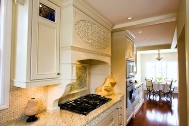 Mid-sized transitional u-shaped dark wood floor and brown floor enclosed kitchen photo in Toronto with granite countertops, multicolored backsplash, stainless steel appliances, no island, an undermount sink, recessed-panel cabinets, beige cabinets, marble backsplash and multicolored countertops