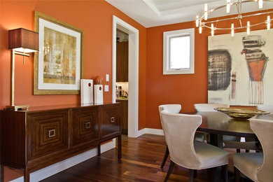 Contemporary dining room in Denver with orange walls.