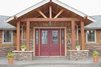 Cette image montre un grand porche d'entrée de maison arrière bohème avec une dalle de béton et une extension de toiture.
