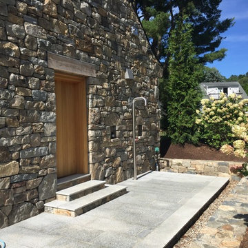 glass tile swimming pool + spa with perimeter overflow + granite decking