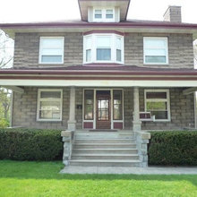 concrete 1907 home with pillars.