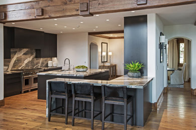 Large medium tone wood floor kitchen photo in Denver with a single-bowl sink, flat-panel cabinets, black cabinets, quartzite countertops, stainless steel appliances and two islands