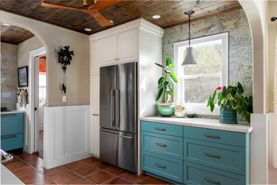Mid-sized eclectic u-shaped porcelain tile, multicolored floor and wood ceiling eat-in kitchen photo in San Francisco with a farmhouse sink, recessed-panel cabinets, multicolored backsplash, terra-cotta backsplash, colored appliances, no island and white countertops