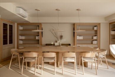 Modelo de comedor contemporáneo grande abierto con paredes beige, suelo laminado, suelo marrón y alfombra
