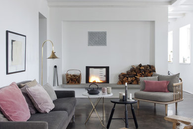 This is an example of a large scandinavian formal open concept living room in Barcelona with white walls, concrete floors, a standard fireplace, no tv and brown floor.