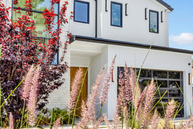 Inspiration for a large country white two-story concrete fiberboard exterior home remodel in Los Angeles with a metal roof and a black roof