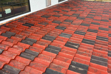 Example of a tuscan exterior home design with a tile roof and a red roof