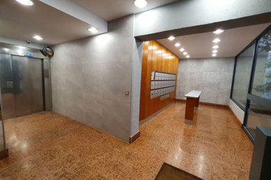 Medium sized modern foyer in Lyon with grey walls, ceramic flooring, a single front door, brown floors and a drop ceiling.