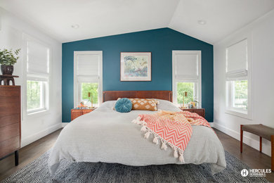 Imagen de dormitorio principal y abovedado retro de tamaño medio con paredes azules, suelo de madera en tonos medios y suelo gris