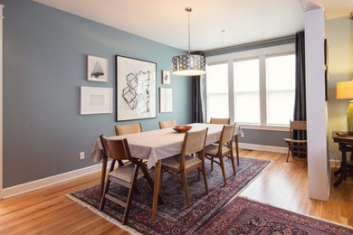 This is an example of a mid-sized midcentury open plan dining in Indianapolis with blue walls, light hardwood floors and no fireplace.