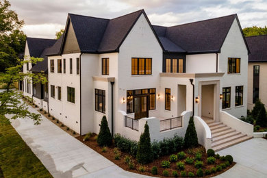 Huge two-story brick house exterior photo in Nashville with a shingle roof and a black roof