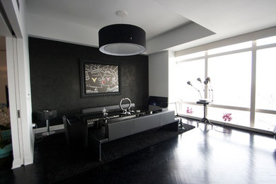 Great room - large modern dark wood floor and black floor great room idea in New York with black walls and no fireplace