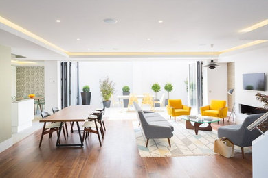 Großes Modernes Wohnzimmer ohne Kamin mit weißer Wandfarbe, braunem Holzboden und braunem Boden in Oxfordshire