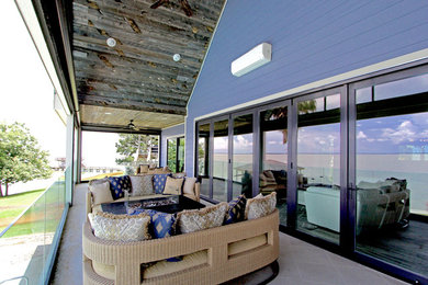 Example of a large beach style backyard patio design in Houston with a roof extension