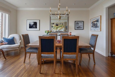 Example of a mid-sized transitional medium tone wood floor and brown floor dining room design in Denver with beige walls