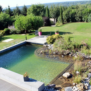 Bild på en mellanstor lantlig anpassad baddamm på baksidan av huset, med spabad och grus