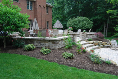 Patio - large traditional backyard stone patio idea in Other with a fire pit and no cover