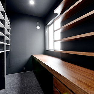 This is an example of a modern study in Tokyo Suburbs with black walls, a built-in desk, carpet, no fireplace and grey floors.