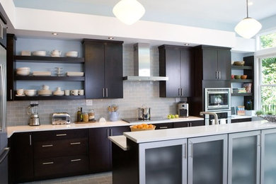 Eat-in kitchen - large contemporary l-shaped travertine floor eat-in kitchen idea in Los Angeles with an undermount sink, flat-panel cabinets, dark wood cabinets, quartz countertops, multicolored backsplash, glass tile backsplash, stainless steel appliances and an island