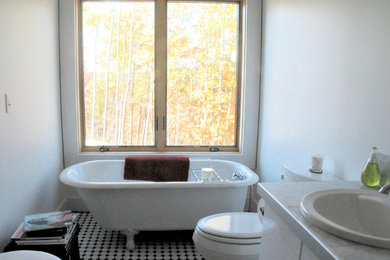 This is an example of a medium sized contemporary family bathroom in Boston with a built-in sink, flat-panel cabinets, white cabinets, granite worktops, a claw-foot bath, a one-piece toilet, white tiles, ceramic tiles, white walls and ceramic flooring.