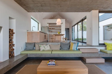 Beach style open concept living room in Perth with white walls, concrete floors and grey floor.