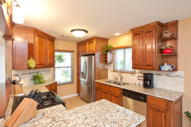 Open concept kitchen - large traditional u-shaped porcelain tile open concept kitchen idea in Austin with a double-bowl sink, medium tone wood cabinets, granite countertops, beige backsplash, stone tile backsplash, stainless steel appliances, raised-panel cabinets and no island