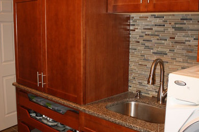 Inspiration for a mid-sized timeless galley slate floor utility room remodel in Detroit with an undermount sink, recessed-panel cabinets, medium tone wood cabinets, granite countertops, beige walls and a side-by-side washer/dryer