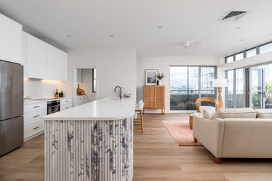 Inspiration for a mid-sized kitchen in Newcastle - Maitland with white cabinets, quartz benchtops, light hardwood floors and white benchtop.