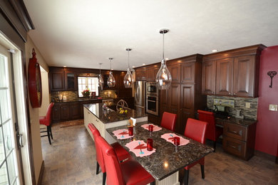 Eat-in kitchen - large transitional porcelain tile eat-in kitchen idea in Other with an undermount sink, raised-panel cabinets, medium tone wood cabinets, quartz countertops, brown backsplash, glass tile backsplash, stainless steel appliances and an island