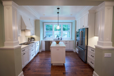 Inspiration for a mid-sized transitional u-shaped medium tone wood floor and brown floor eat-in kitchen remodel in Grand Rapids with a double-bowl sink, recessed-panel cabinets, white cabinets, quartz countertops, white backsplash, mosaic tile backsplash, stainless steel appliances, an island and white countertops
