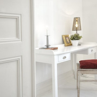 This is an example of a traditional craft room in Stockholm with white walls, painted wood floors, no fireplace, a freestanding desk and white floor.