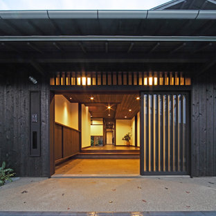 Новый формат декора квартиры: узкая прихожая среднего размера в восточном стиле с черными стенами, темным паркетным полом, раздвижной входной дверью, черной входной дверью и черным полом