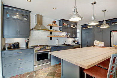 Enclosed kitchen - mid-sized traditional single-wall travertine floor and beige floor enclosed kitchen idea in Montreal with an undermount sink, shaker cabinets, gray cabinets, wood countertops, white backsplash, subway tile backsplash, stainless steel appliances and an island