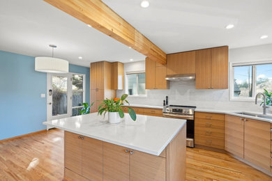 Inspiration for a mid-sized modern l-shaped eat-in kitchen in Portland with an undermount sink, flat-panel cabinets, medium wood cabinets, quartz benchtops, white splashback, ceramic splashback, stainless steel appliances, medium hardwood floors, with island, beige benchtop and exposed beam.
