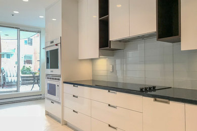 Inspiration for a modern l-shaped ceramic tile and beige floor enclosed kitchen remodel in Vancouver with an undermount sink, shaker cabinets, white cabinets, quartz countertops, white backsplash, glass tile backsplash and white appliances