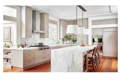 Inspiration for a large contemporary l-shaped medium tone wood floor and brown floor eat-in kitchen remodel in Toronto with raised-panel cabinets, beige cabinets, marble countertops, white backsplash, marble backsplash, stainless steel appliances, an island and white countertops