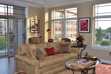 Example of a large classic open concept dark wood floor living room design in Chicago with beige walls, no fireplace and a concealed tv